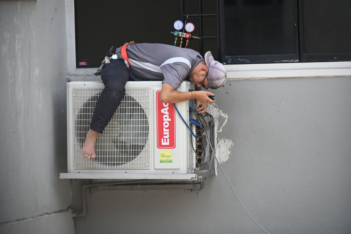 Técnico instalando un equipo de aire acondicionado, ilustrando la cobertura del seguro de hogar
